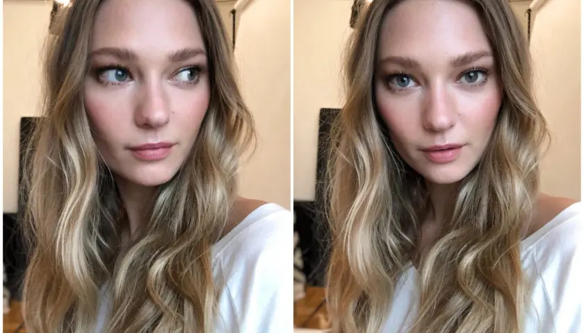 En kvinna med blont, vågigt hår och en subtil, naturlig makeup som framhäver hennes blå ögon och rosiga kinder.