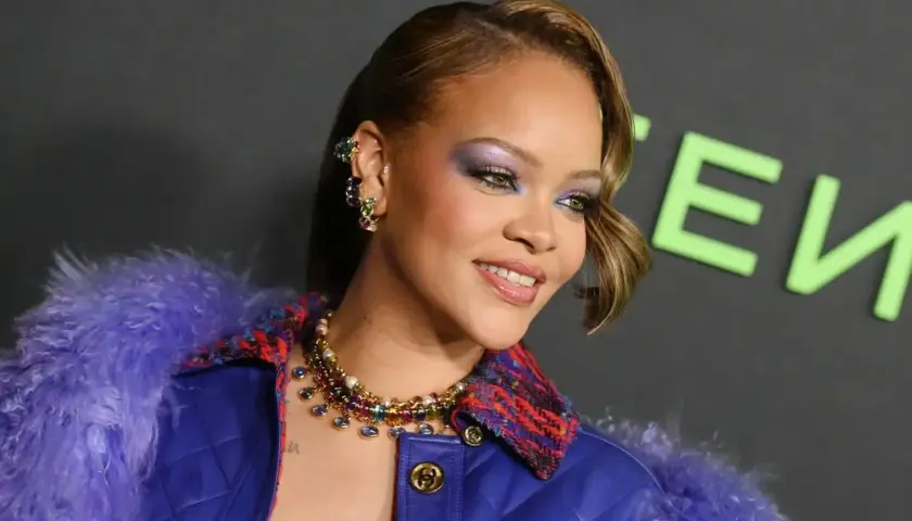 Rihanna w fioletowym futrze i biżuterii, z makijażem oczu.