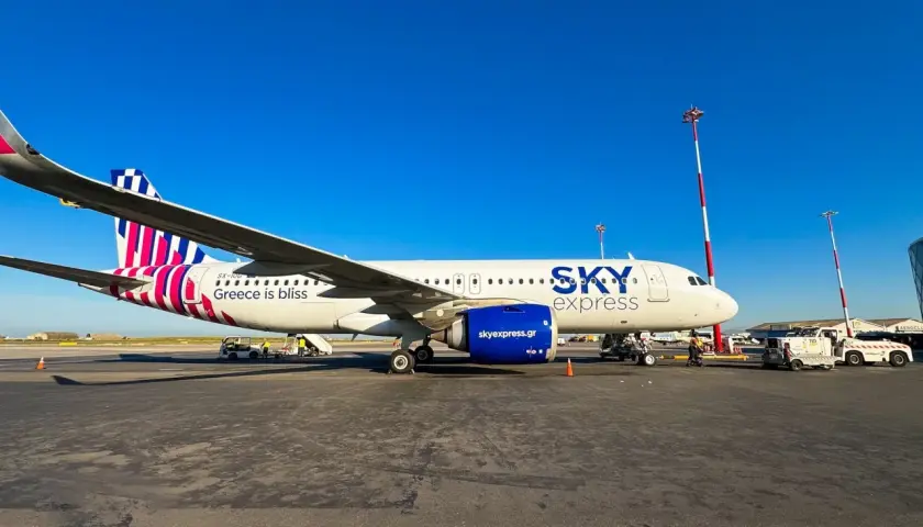 Samolot greckich linii lotniczych Sky Express na płycie lotniska. Napis "Greece is bliss" zapowiada podróż.