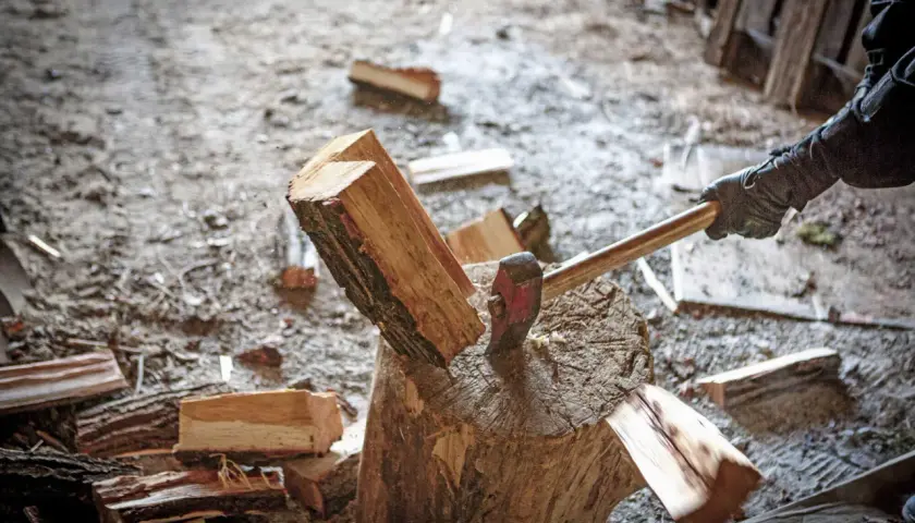 Axt spaltet Holzscheit. Informiere dich über aktuelle brennholz preise bayern, um dein Zuhause warm zu halten.