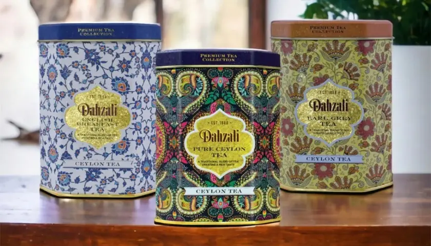 Trzy ozdobne puszki herbaty Dahzali z wzorami kwiatowymi i paisley.