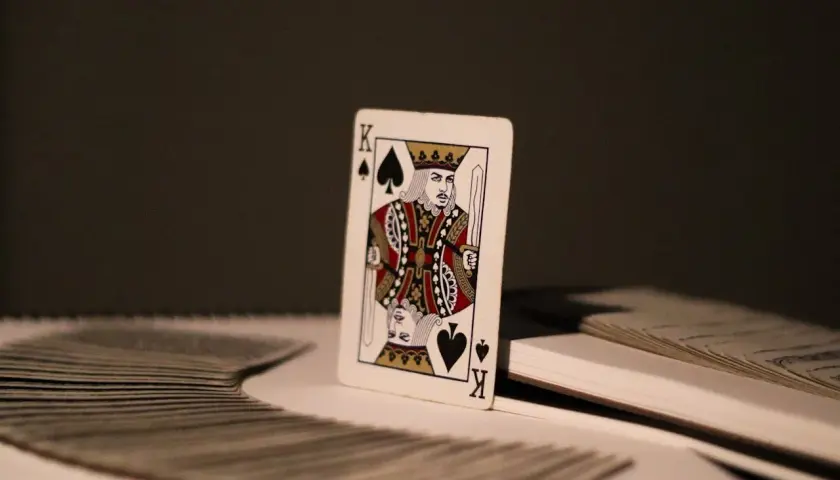 Król pik znaczenie. Pojedyncza karta, król pik, stoi na stosie kart.
