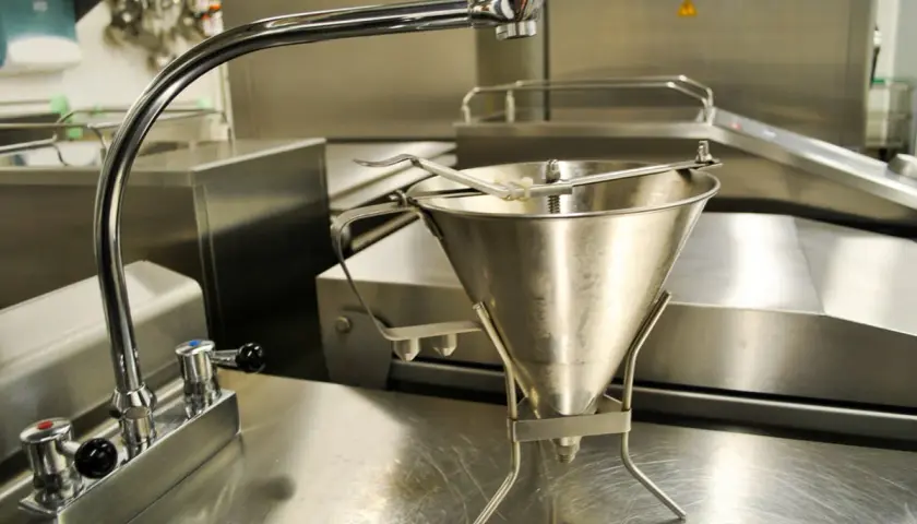 Un entonnoir à pâte en type inox, prêt à être utilisé dans une cuisine professionnelle.