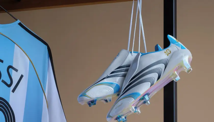 Białe korki z niebieskimi i złotymi detalami, wiszące obok koszulki z napisem "MESSI". To w takich korkach grał Messi, świętując 10-lecie.