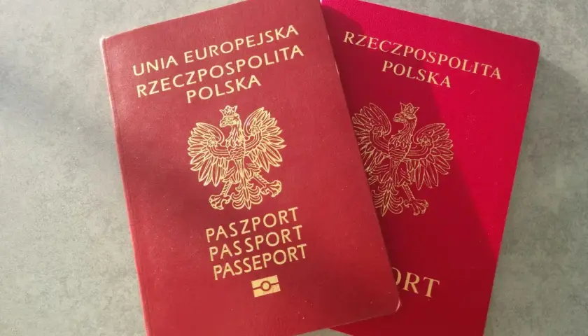 Dwa polskie paszporty w kolorze czerwonym leżą obok siebie.