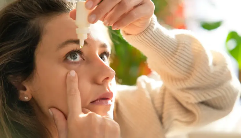 Donna applica collirio per alleviare i sintomi della congiuntivite allergica, cercando sollievo rapido.