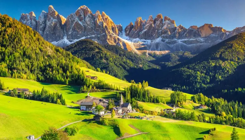 Un village pittoresque dans les Dolomites en Italie, idéal pour le camping. Des montagnes majestueuses, des prairies verdoyantes et des chalets traditionnels.