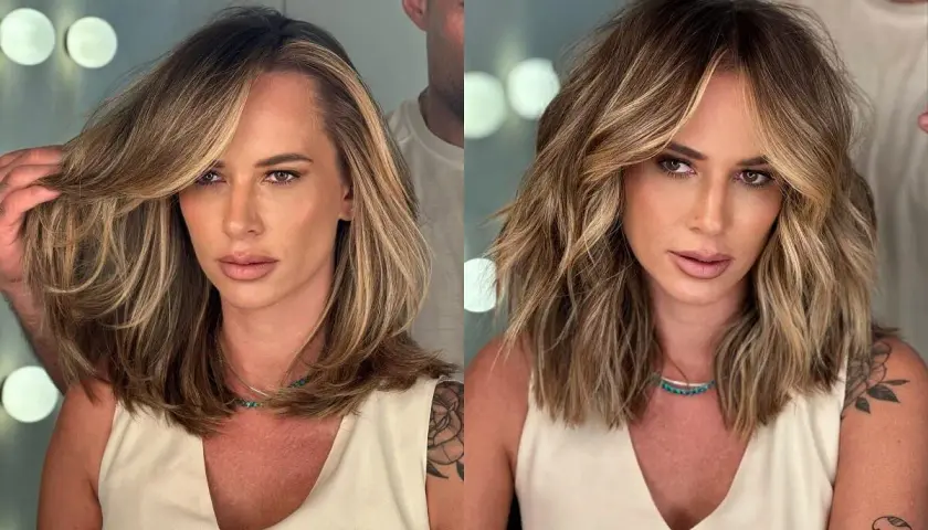 Kobieta z burzą blond włosów, które stylista układa, pokazując, jak zmniejszyć objętość włosów.