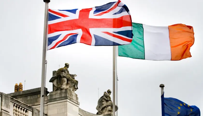 Union Jack und irische Flagge wehen nebeneinander. Die EU-Flagge ist im Hintergrund zu sehen.