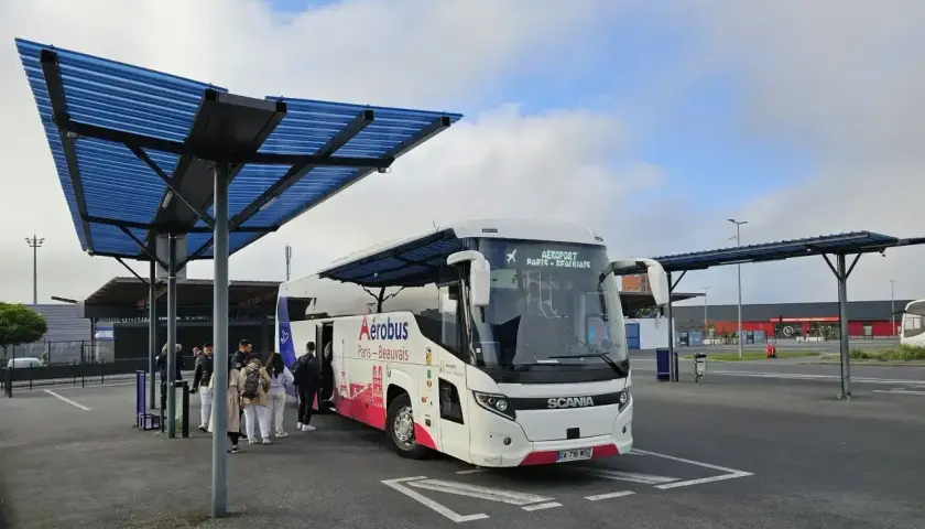 Autobus Aerobus z napisem "Paris-Beauvais" czeka na pasażerów pod niebieskim zadaszeniem.