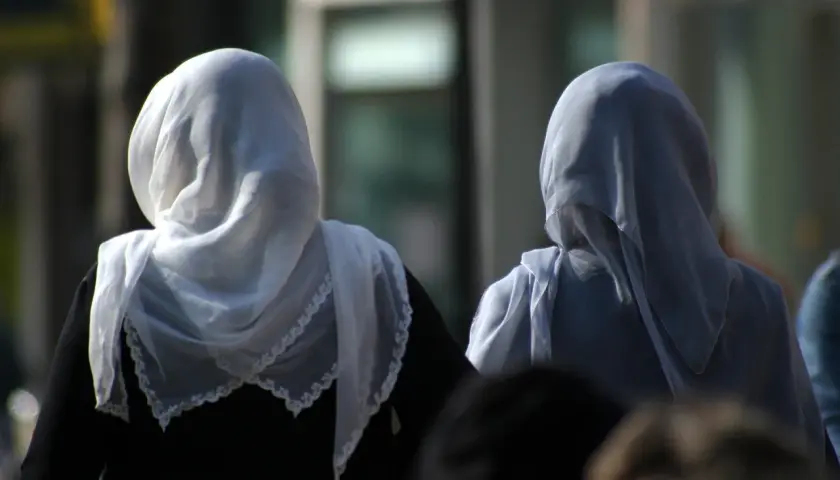 Dwie kobiety w hidżabach, symbolizujące tradycję i to, czego nie wolno kobietom w Turcji, idą ulicą.