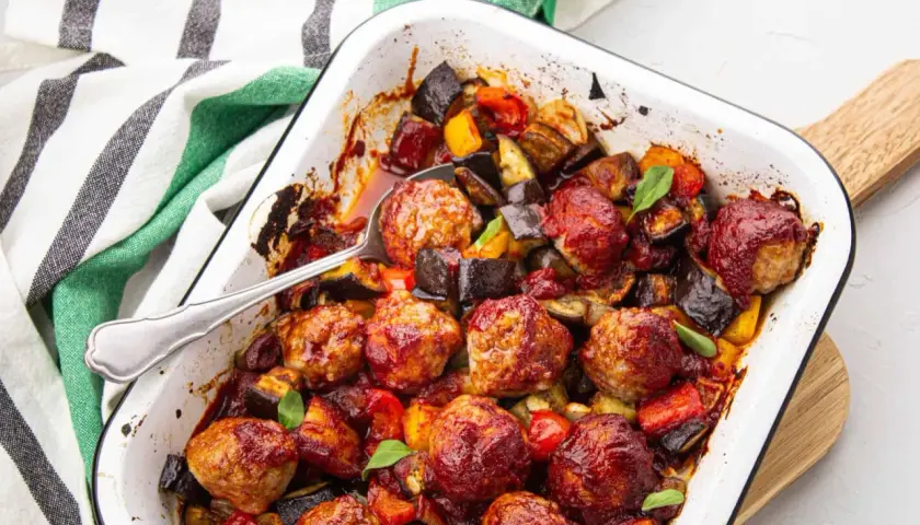 Un plat réconfortant de boulettes de viande barbecue, enrobées d'une sauce savoureuse, mijotant avec des légumes rôtis comme l'aubergine et le poivron.