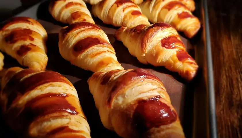 Une fournée de croissants dorés, parfaits pour une recette facile. Ils sont brillants et appétissants.