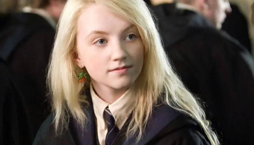 Evanna Lynch jako Luna Lovegood, z charakterystycznymi kolczykami z koralików, w szkolnym mundurku.