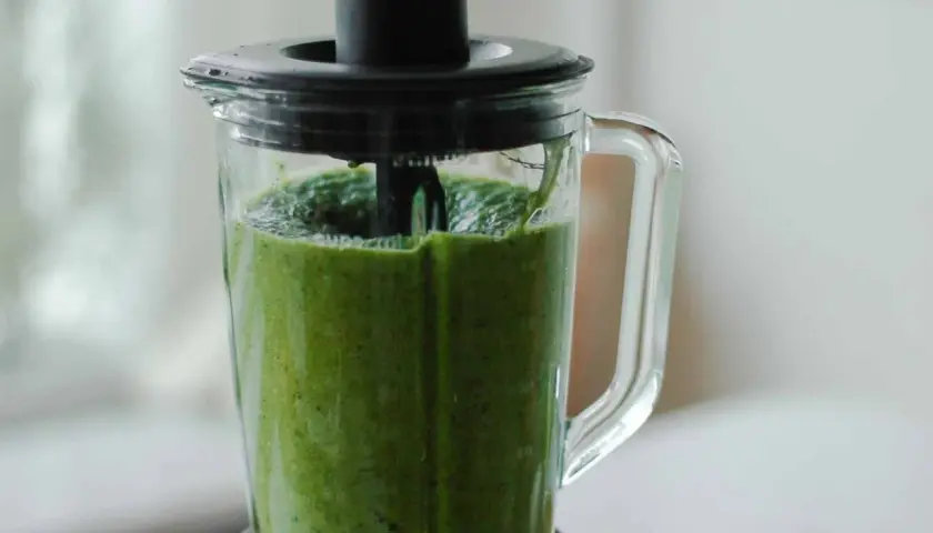 Ein grüner Smoothie wird im Mixer zubereitet. Dieses grüne Saft Rezept ist voller Vitamine.