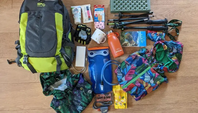 Plecak, kijki trekkingowe, bukłak i kolorowe ubrania – wszystko gotowe na wyprawę w góry.
