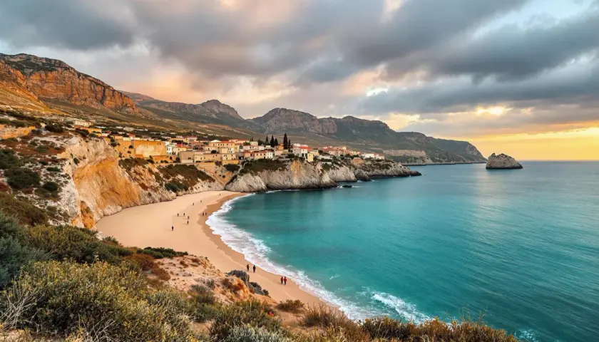 Traumhafte Bucht mit Sandstrand, türkisfarbenem Meer und einer kleinen Stadt an der Küste. Das Wetter auf Sardinien im Oktober ist hier ideal für einen Spaziergang.