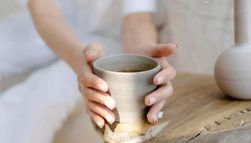 Sanfte Hände halten eine Tasse Brennnesseltee. Ob morgens oder abends, dieser Tee ist ein Genuss.