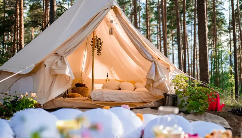 Przytulny namiot w lesie, idealny na glamping noclegi. Wygodne łóżko, dekoracje i atmosfera relaksu.