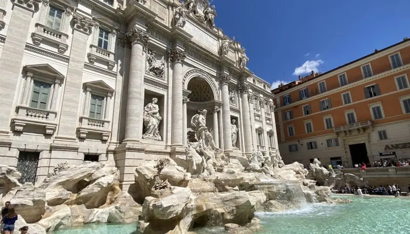 Fontaine de Trevi, un chef-d'œuvre baroque à Rome, Italie, avec des touristes admirant sa splendeur sous un ciel bleu.
