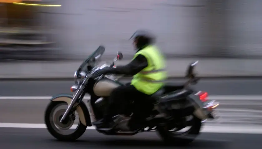 Motociclista con chaleco reflectante, esencial para la seguridad. Es obligatorio llevar chaleco reflectante en la moto.