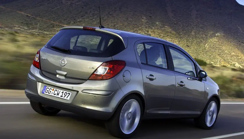 Szary Opel Corsa D 1.2 na drodze, z widocznym rozmiarem opon.