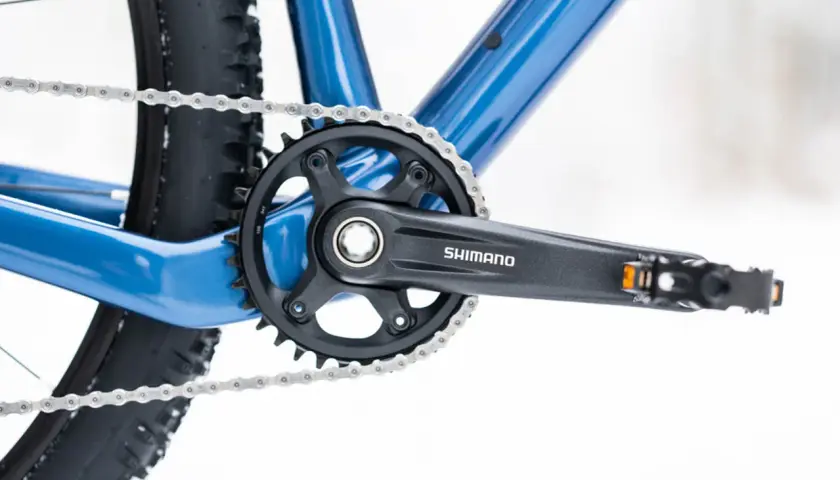 Widok na korbę Shimano i łańcuch roweru. Dowiedz się, jak odkręcić pedały w rowerze, by wymienić je na nowe.