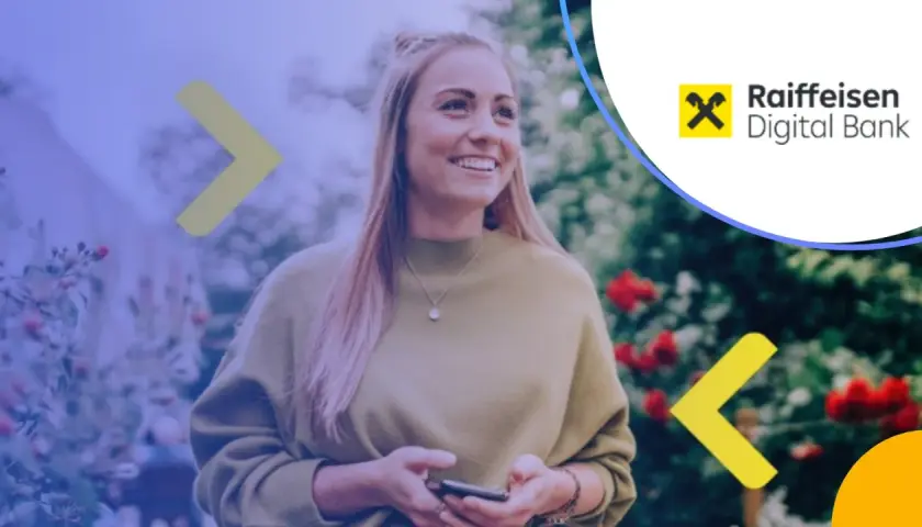 Uśmiechnięta kobieta z telefonem w ręku, korzystająca z usług Raiffeisen Digital Bank.
