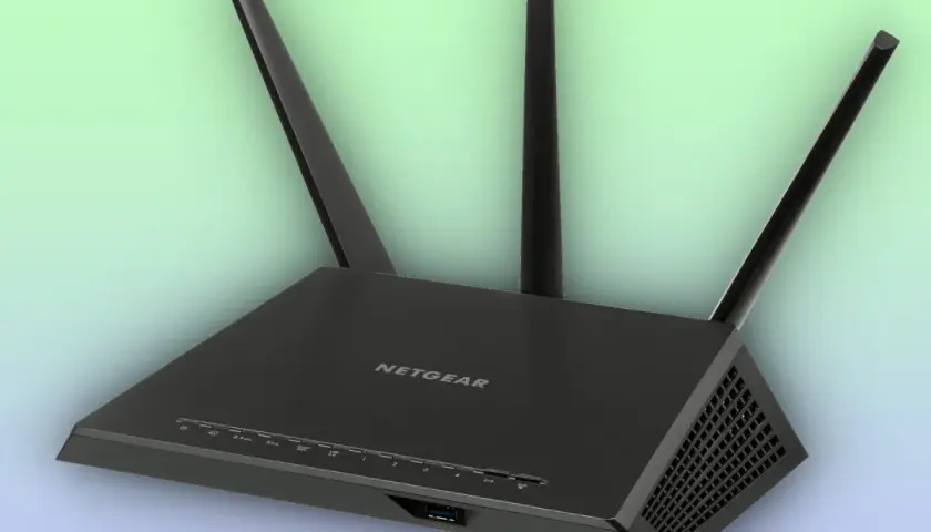 Un enrutador Netgear negro con tres antenas, esencial para tu conexión a internet.