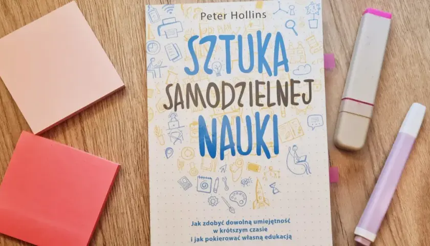 Książka "Sztuka samodzielnej nauki" leży obok różowych karteczek i zakreślaczy. Idealna do nauki angielskiego.