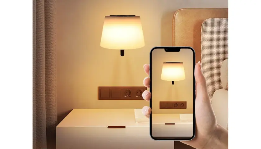 Elegancki kinkiet nad stolikiem nocnym, widoczny na ekranie telefonu. Idealne oświetlenie do sypialni.