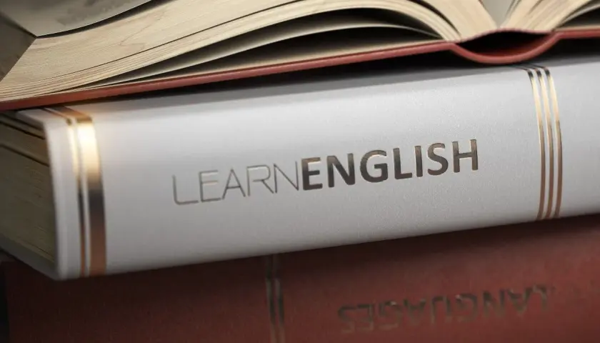 Stos książek, na wierzchu otwarta, z napisem "LEARN ENGLISH" na białej okładce. Idealne książki po angielsku do nauki.