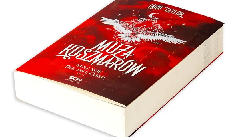Okładka książki "Muza Koszmarów" Laini Taylor. Tytuł "Strange the Dreamer" sugeruje, że to opowieść o kimś, kto żyje marzeniami.