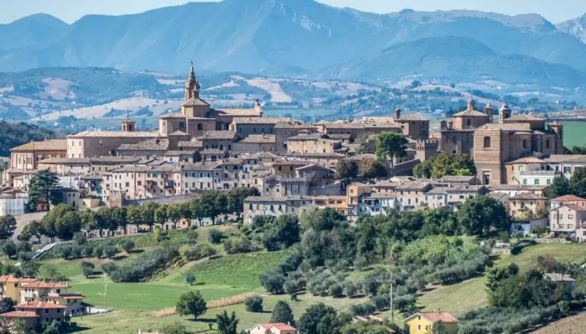 Panoramica di Corinaldo, borgo medievale nelle Marche, con le sue case in pietra e le colline verdi circostanti.