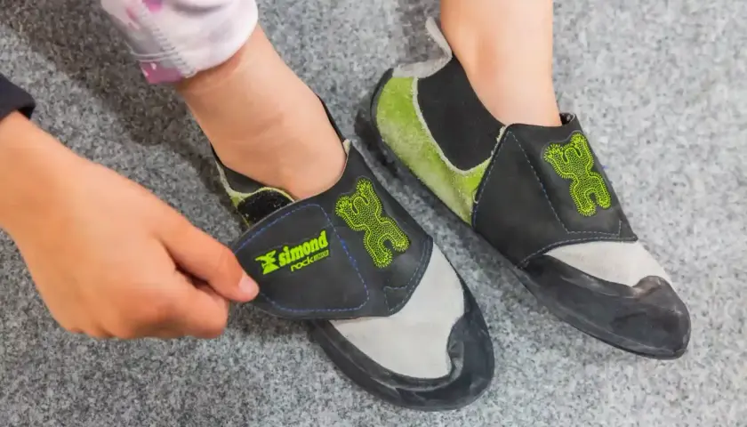 Pies de gato con un diseño de rana verde, listos para escalar. Se ven cómodos, con o sin calcetines.