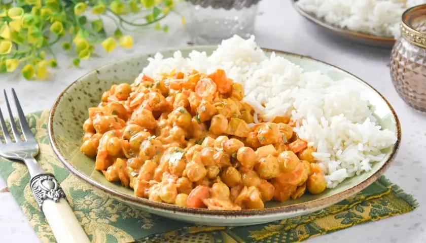 Plato de arroz al curry con garbanzos y zanahoria, servido con arroz blanco esponjoso.