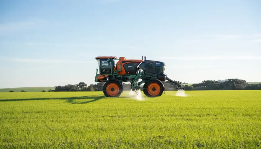 Pulvérisateur agricole Stara 3000 en action, assurant le nettoyage et la protection des cultures dans un champ verdoyant sous un ciel bleu.