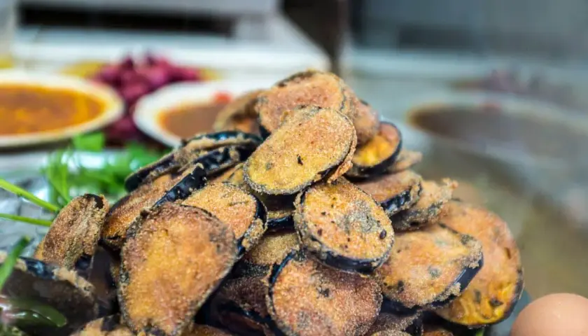 Un tas de beignets d'aubergine dorés et croustillants, prêts à être dégustés.