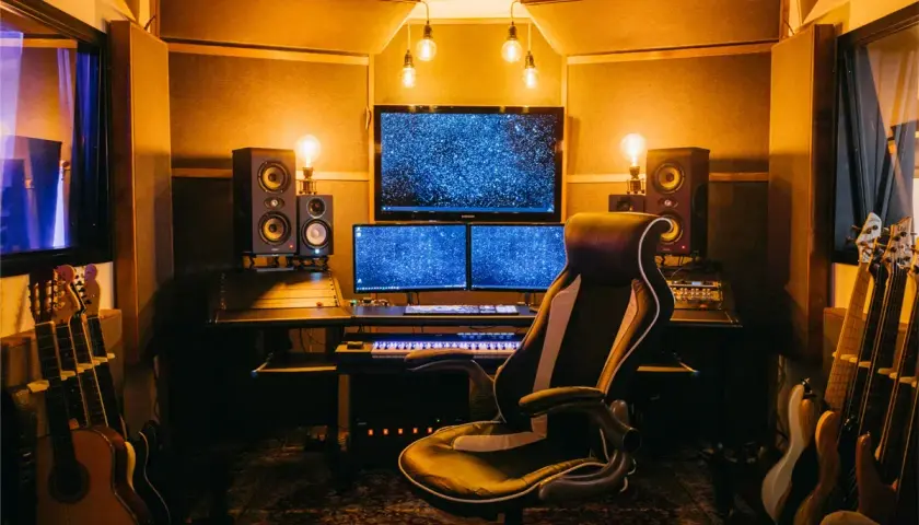 Ein Tonstudio mit Monitoren, Lautsprechern und Gitarren. Hier wird der **sound mixing** perfektioniert.