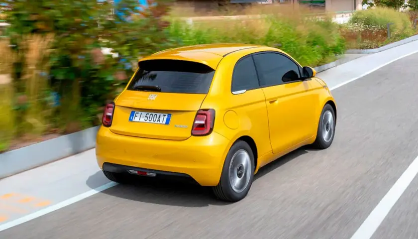 Un Fiat 500 Hybrid amarillo brillante en movimiento. ¡Una prueba de manejo emocionante!
