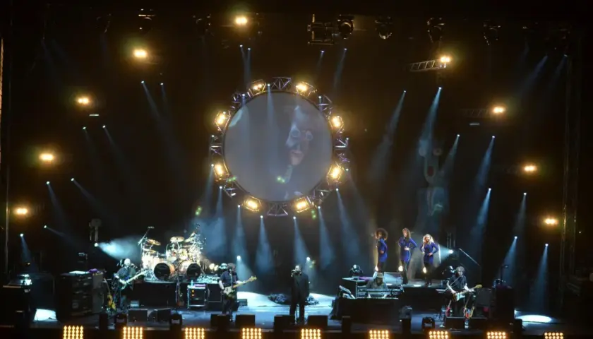 Koncert Australian Pink Floyd z okrągłym ekranem i wokalistami na scenie.