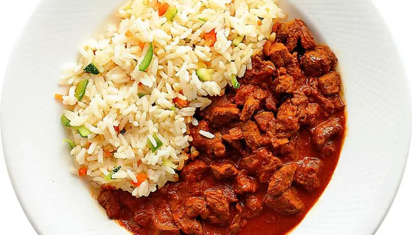 En portion ungersk gulasch med ris och grönsaker. Köttet är mört och såsen rik.