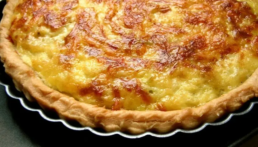 Une quiche aux poireaux dorée et appétissante, avec une croûte croustillante et une garniture crémeuse. Parfaite pour un repas réconfortant.