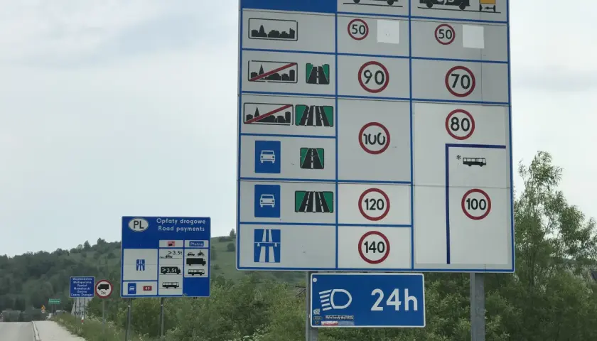 Znaki drogowe informujące o opłatach i ograniczeniach prędkości. Przygotuj się na jazdę w terenie zabudowanym i poza nim.