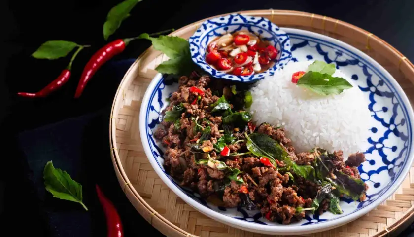 En portion pad kra pao med ris, chilipickles och färska chilifrukter.