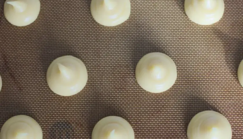 Chouquettes prêtes à cuire sur une plaque. Pour bien conserver des chouquettes, il faut les laisser refroidir complètement avant de les stocker.