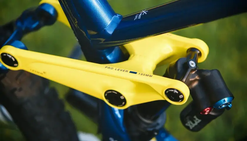 Żółte ramię korby z napisem "PRO LEVER 180MM" na tle niebieskiej ramy roweru.