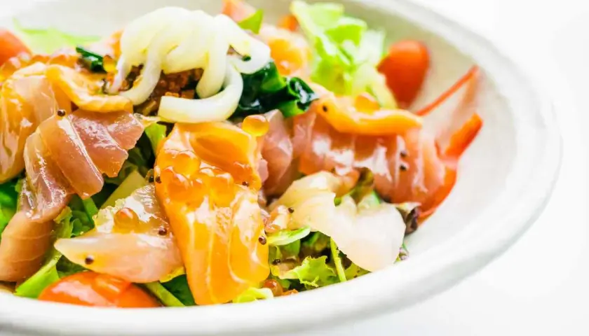 Deliziosa insalata di mare con verdure fresche, salmone affumicato, gamberi e uova di pesce, un tripudio di sapori e colori.