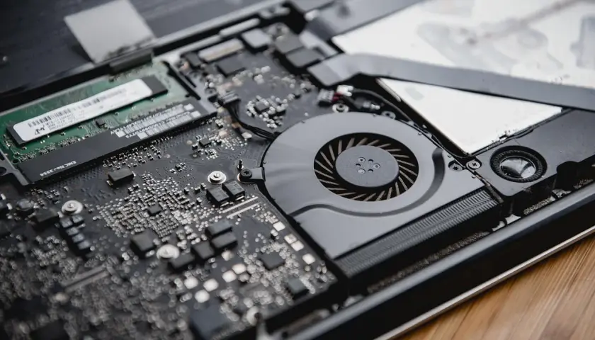 Vue rapprochée des composants internes d'un ordinateur portable, dont la RAM, essentielle pour la rapidité de traitement.