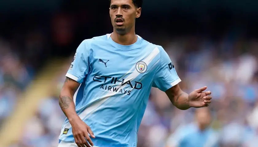 Piłkarz Manchester City w jasnoniebieskiej koszulce z logo klubu i napisem Etihad Airways.